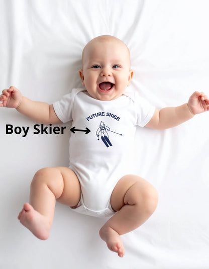 Baby wearing a white onesie with 'Future Skier' text and ski motif