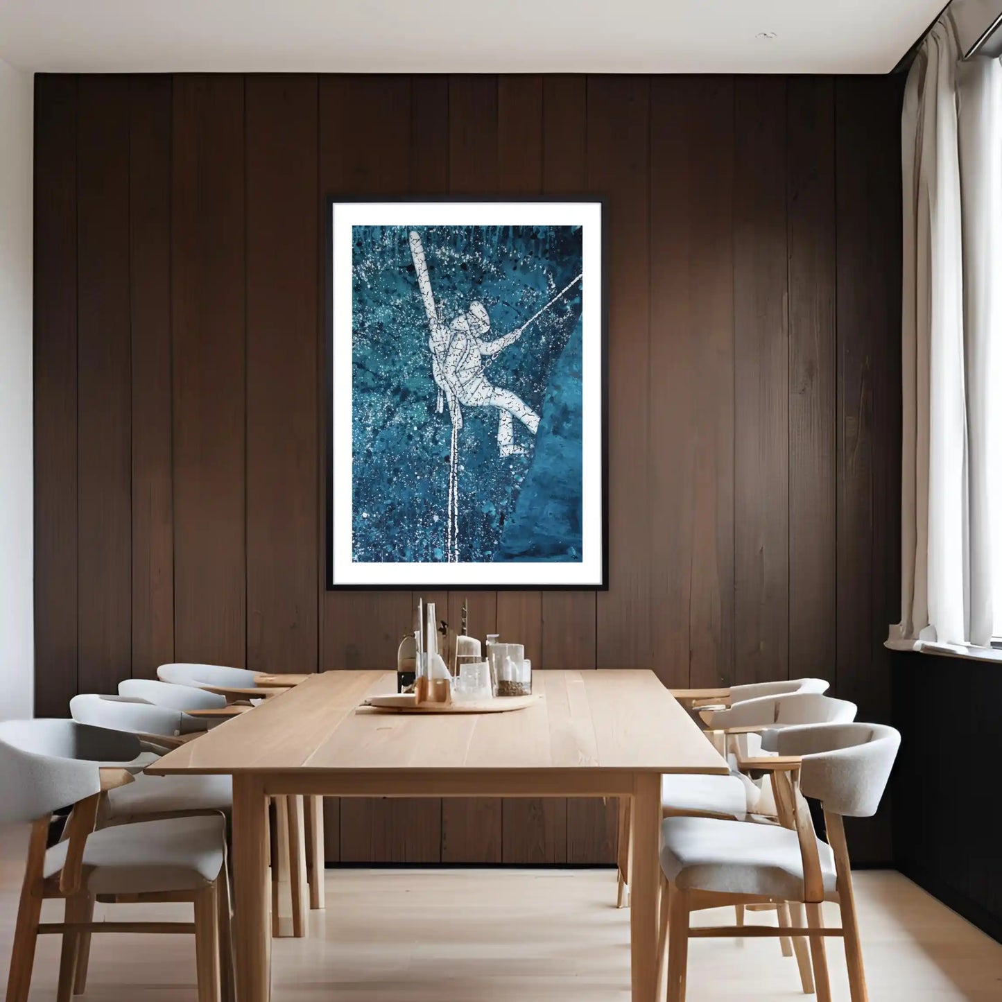 Dining room with wooden table and chairs, framed ski artwork on the wall.